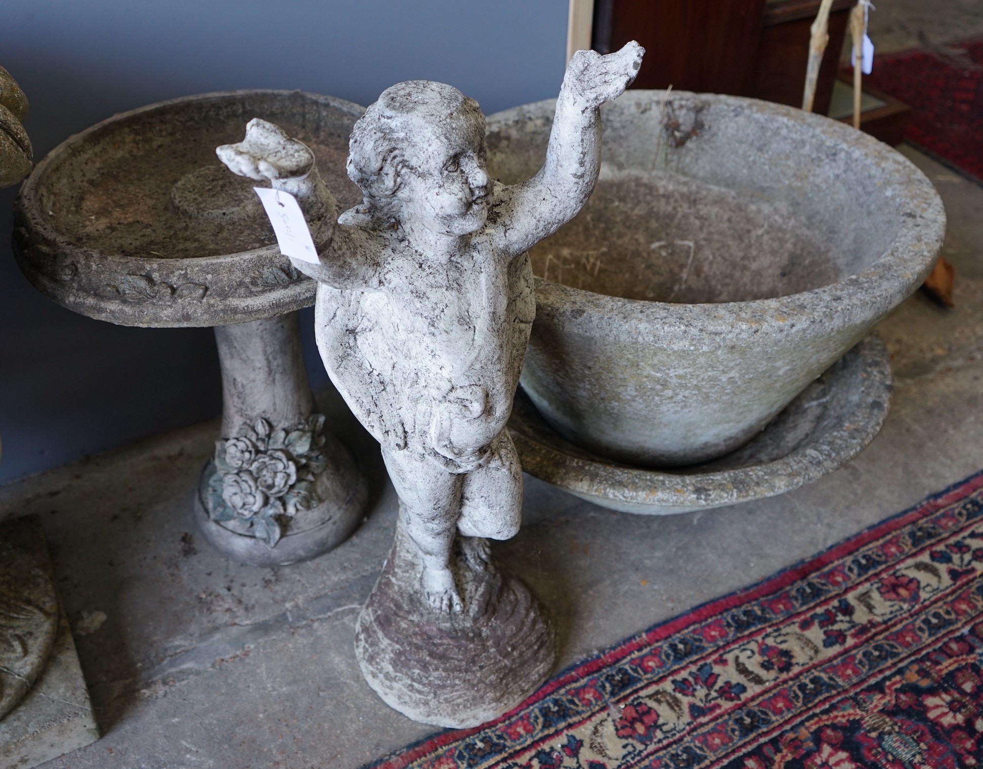 A circular reconstituted stone bird bath, height 50cm, a pair of circular planters and a cherub ornament